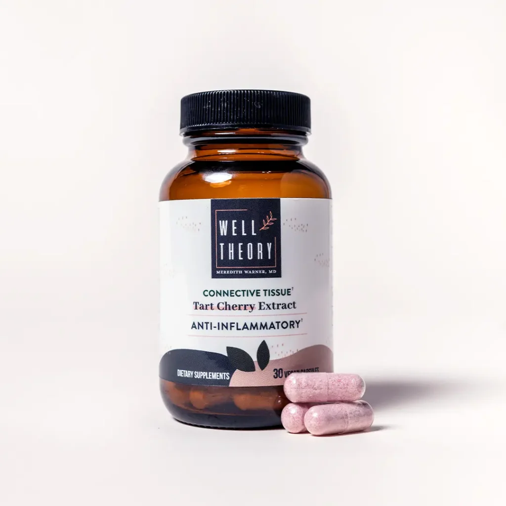 A brown "Well Theory Tart Cherry Extract" bottle for inflammation with three pink capsules on a light background.